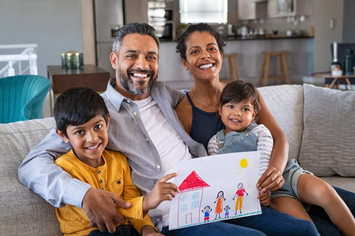 Happy ethnic family showing painting with new home Immigration legal help North Texas